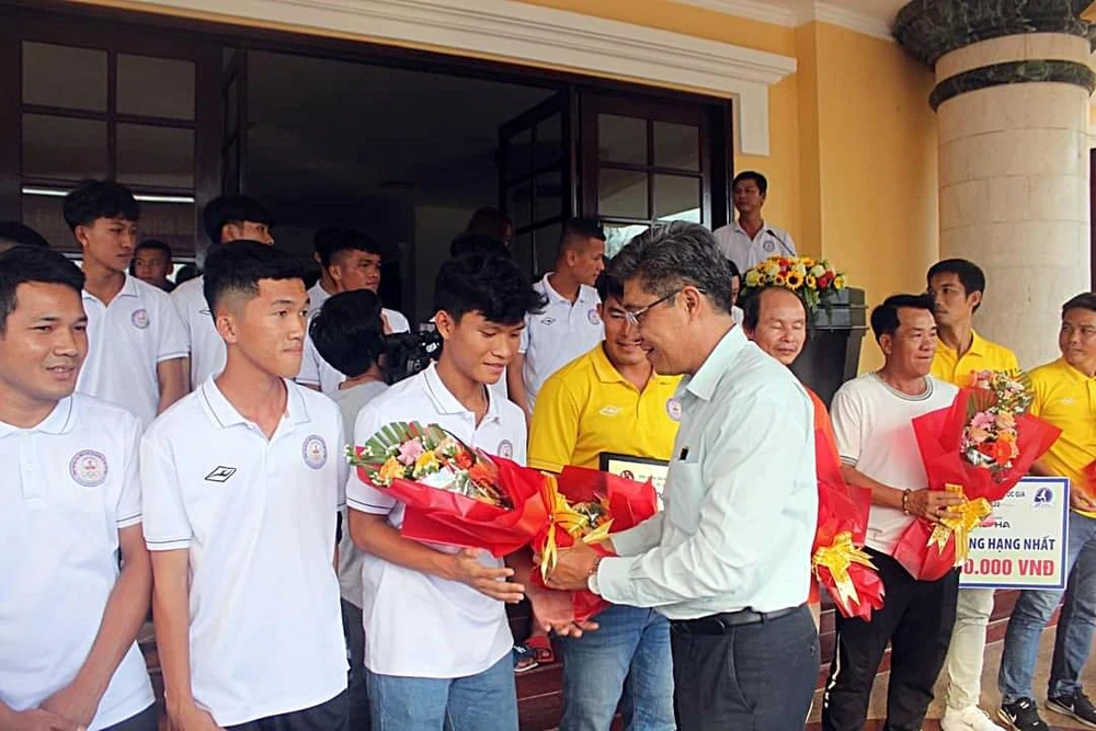Ông Nguyễn Minh, Phó Chủ tịch UBND tỉnh tặng hoa chúc mừng các cầu thủ sau khi thăng hạng Nhất.