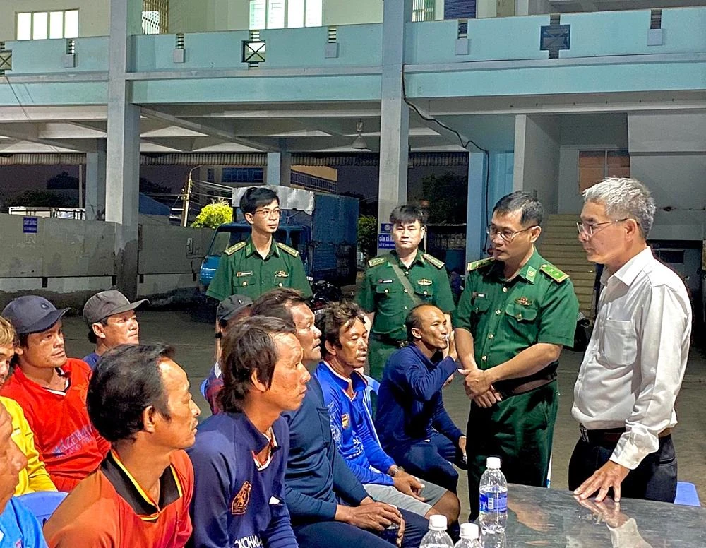 Ông Lê Văn Chơn (bìa phải) cùng biên phòng đón 14 thuyền viên gặp nạn. Ảnh: TR.THÀNH