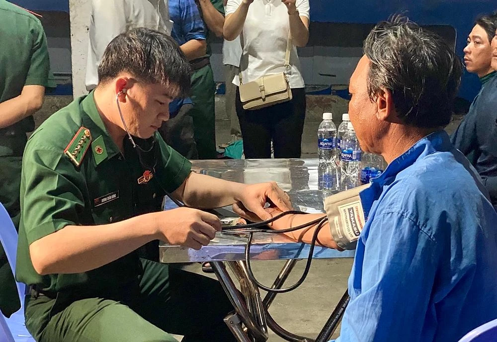 Biên phòng Bình Thuận chăm sóc y tế cho các thuyền viên gặp nạn. Ảnh: TRUNG THÀNH