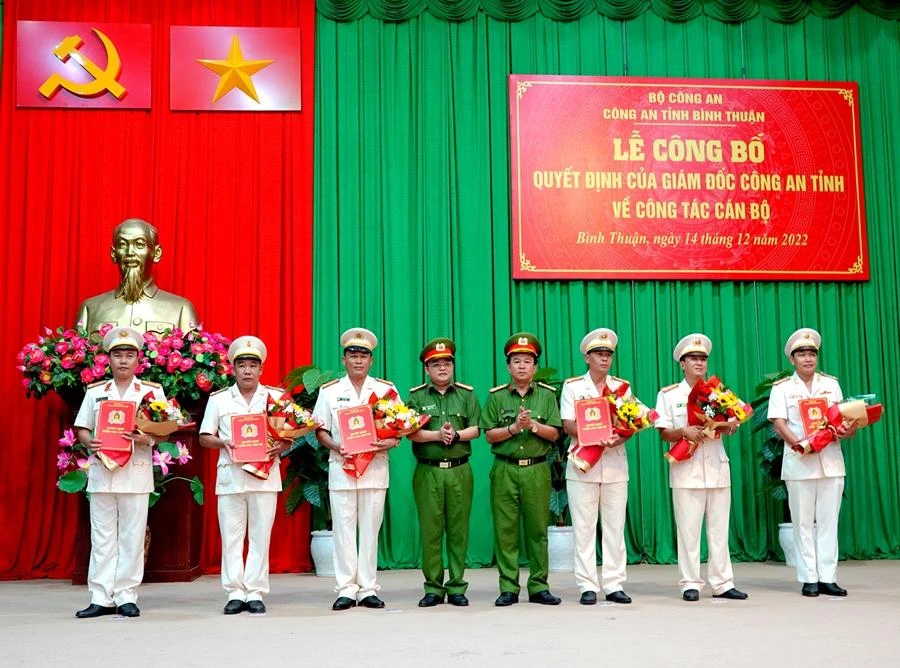 Đại tá Đinh Kim Lập và Thượng tá Huỳnh Ngọc Liêm trao quyết định, tặng hoa cho sáu sĩ quan vừa được điều động, bổ nhiệm. Ảnh: NHƯ Ý
