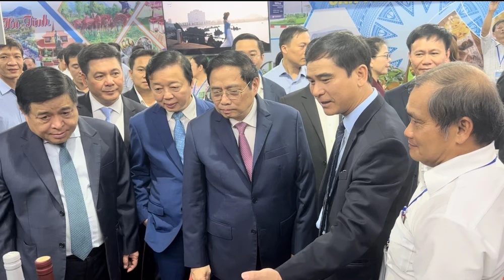 Bí thư Tỉnh ủy Bình Thuận Dương Văn An (thứ 2 từ phải sang) giới thiệu với Thủ tướng gian hàng sản phẩm của Bình Thuận. Ảnh BT.