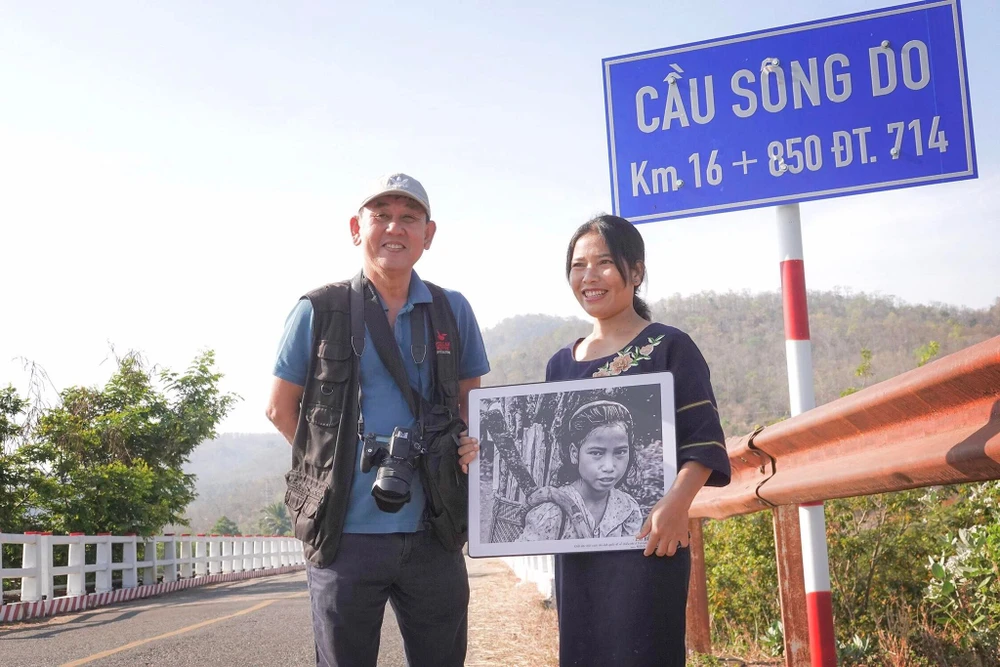 Nghệ sĩ nhiếp ảnh Hữu Thành trao tặng bức ảnh Em bé K'ho cho K'Thi Rầm.