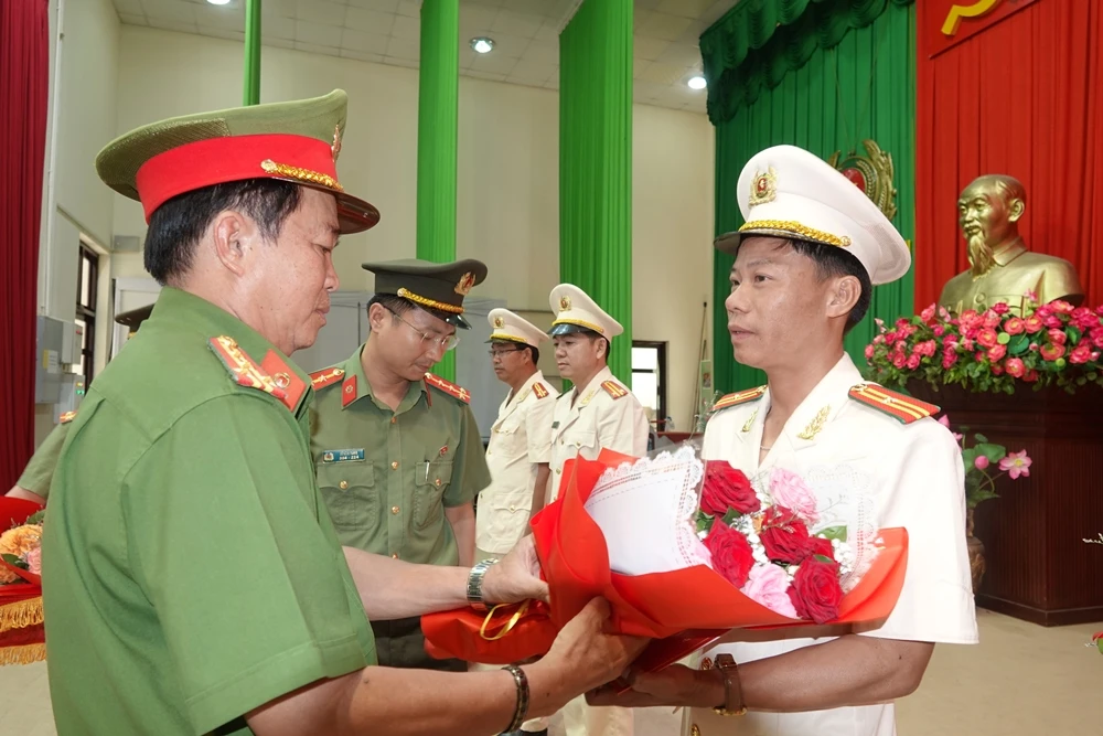Đại tá Đinh Kim Lập tặng hoa chúc mừng các sĩ quan vừa được điều động, bổ nhiệm.