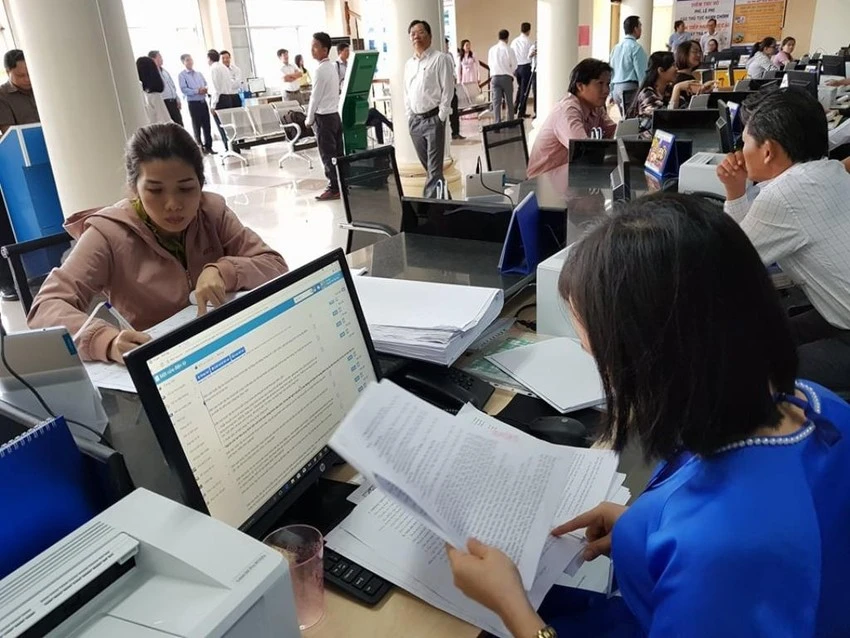 Công chức, viên chức đang giải quyết hồ sơ cho dân tại Trung tâm Hành chính công. Ảnh PN.