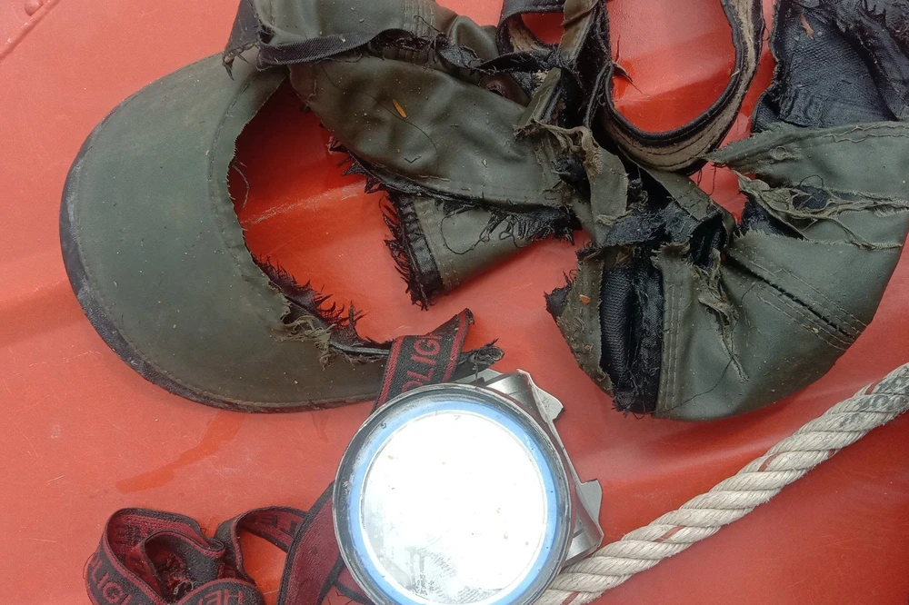 Chiếc mũ và đèn pin đội đầu của nạn nhân. Ảnh NK.