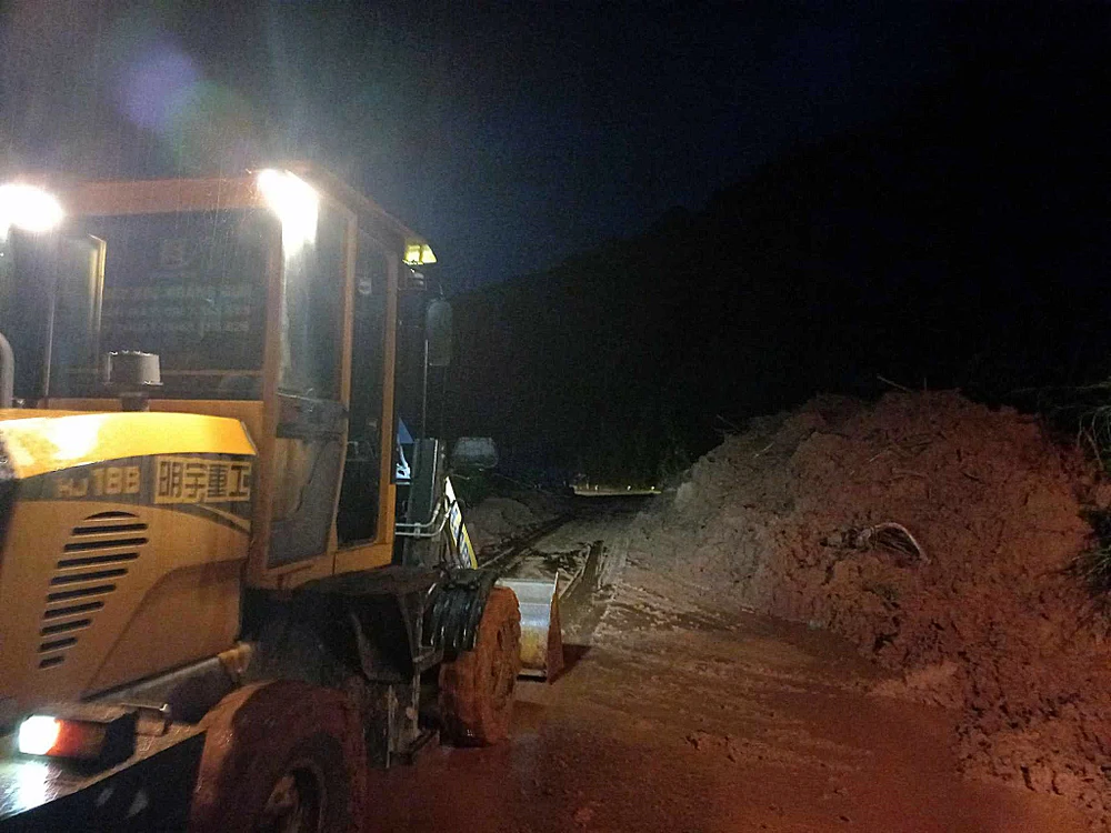 Xe cơ giới dọn dẹp sạt lở tại đèo Đa Mi. Ảnh AK.