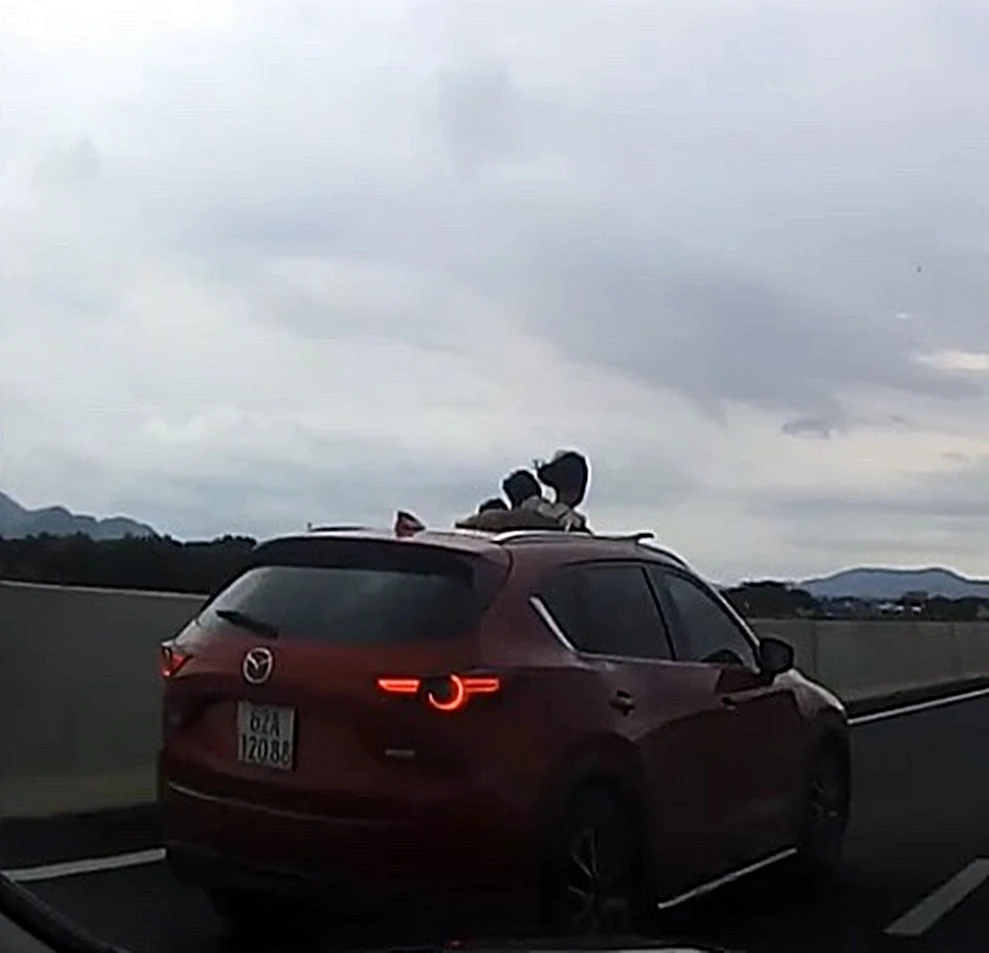 Ôtô mở cửa sổ trời cho trẻ em ló đầu ra ngoài trên cao tốc vô cùng nguy hiểm. Ảnh cắt từ camera