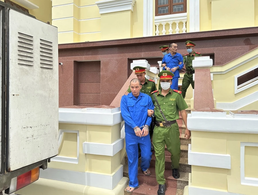 Cảnh sát dẫn giải hai bị cáo ra xe về trại giam. Ảnh: PĐ Cảnh sát dẫn giải hai bị cáo ra xe về trại giam. Ảnh: PĐ