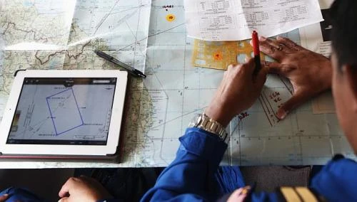 Một phi công Malaysia đang nghiên cứu bản đồ trên máy bay phản lực Gulfstream V của Cảnh sát biển Nhật Bản. Ảnh: Reuters