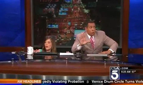 Hai người dẫn chương trình Chris Schauble và Megan Henderson nấp xuống gầm bàn để trú ẩn.