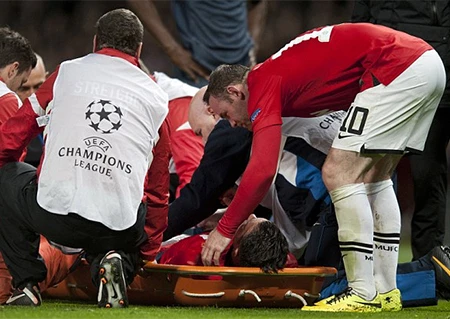 Rooney giúp các nhân viên y tế đưa Van Persie ra sân