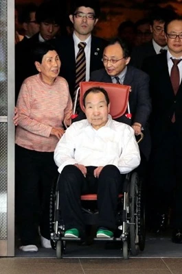 Iwao Hakamada leaves a hotel in Tokyo with his sister, Hideko, to his left, on March 28. (Kazuhiro Nagashima)