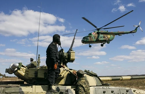 Ukrainian soldiers watch as an army medic helicopter flies above during a military exhibition near the settlement of Desna in Chernigov region, April 2, 2014