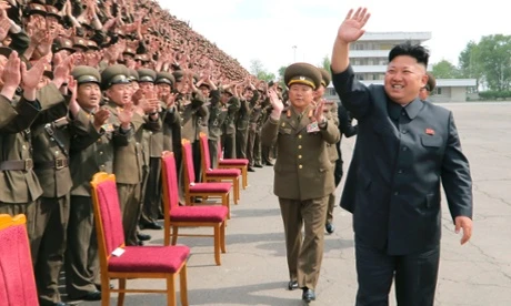 North Korean leader Kim Jong-un waves during a photo session with soldier-builders in this undated photo released by North Korea's Korean Central News Agency