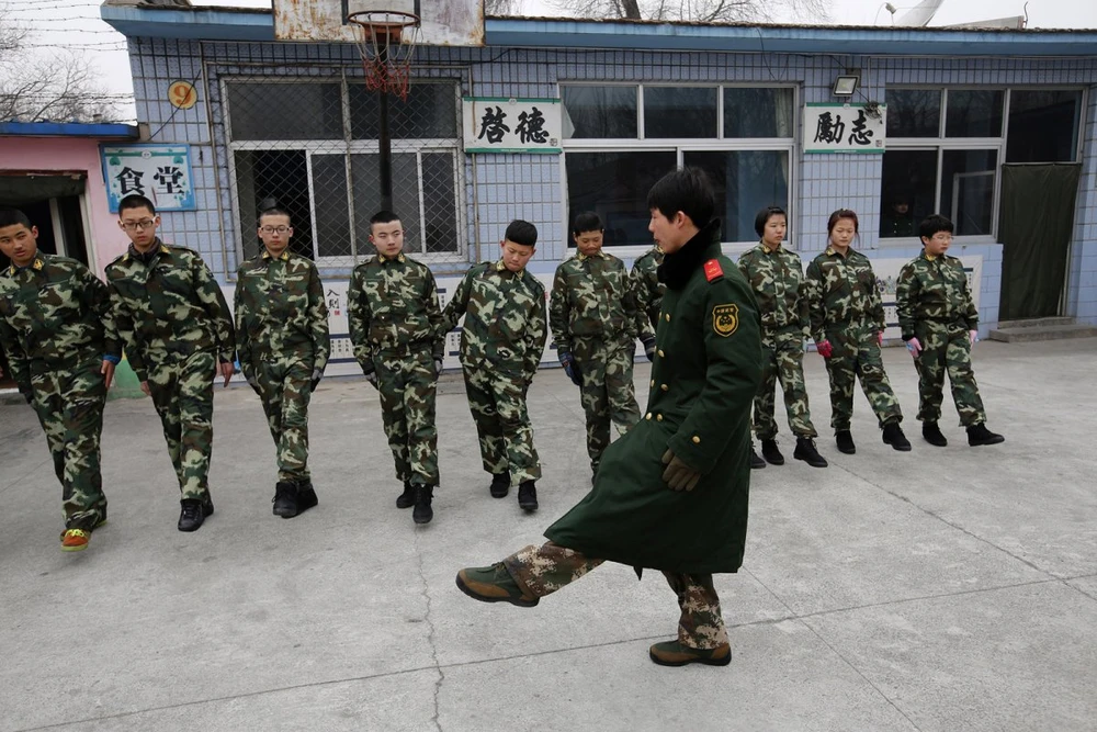 Một cựu giảng viên quân sự dạy học viên cách đi đều bước. Hầu hết thanh thiếu niên tới đây theo yêu cầu của cha mẹ.