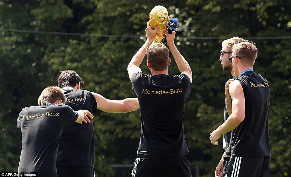 Thomas Muller nâng cao chiếc cúp vàng thế giới trước sự phấn khích của những người hâm mộ.