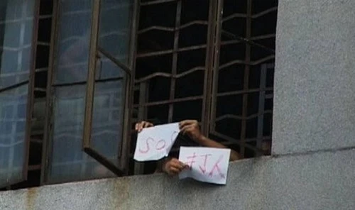 Ảnh chụp từ phía ngoài cửa sổ của một trung tâm cai nghiện internet. Các em học sinh dường như đang kêu cứu.