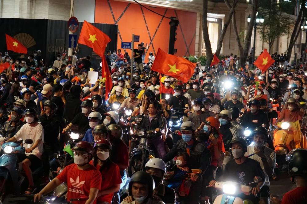 Sau khi giành chiến thắng, ‘cơn bão’ đã đổ về TP.HCM, tất cả mọi người hòa chung không khí vui mừng chưa từng có, người cầm cờ, người cầm nồi, thau, kèn… xuống đường vòng quanh các tuyến đường trung tâm TP.HCM để ăn mừng chiến thắng của tuyển nhà. Ảnh: BẢO PHƯƠNG Sau khi giành chiến thắng, ‘cơn bão’ đã đổ về TP.HCM, tất cả mọi người hòa chung không khí vui mừng chưa từng có, người cầm cờ, người cầm nồi, thau, kèn… xuống đường vòng quanh các tuyến đường trung tâm TP.HCM để ăn mừng chiến thắng của tuyển nhà. Ảnh: BẢO PHƯƠNG