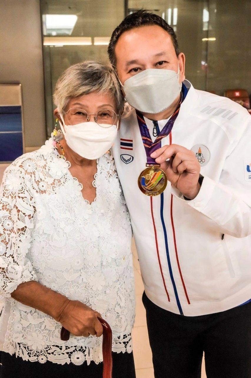 Wattana Pu-ob-orm chụp ảnh cùng mẹ ông bên cạnh chiếc HCV SEA Games 31. Wattana Pu-ob-orm chụp ảnh cùng mẹ ông bên cạnh chiếc HCV SEA Games 31.