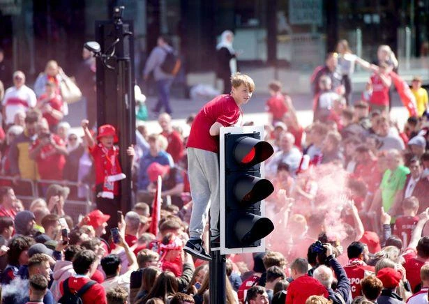 Một fan nhí leo lên cả trụ đèn giao thông. ẢNH: PA