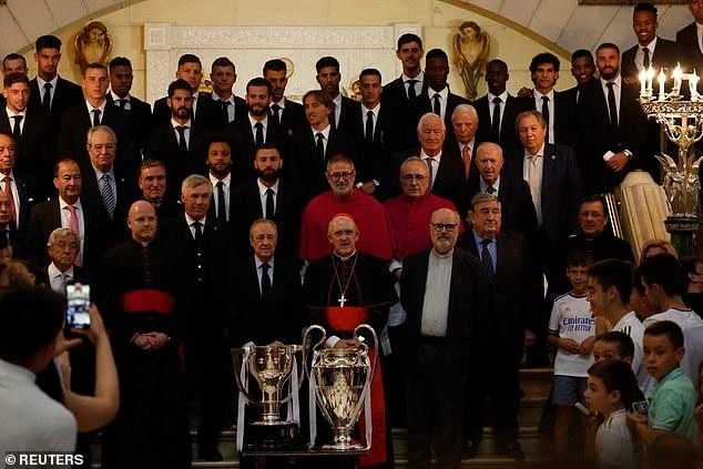 Chủ tịch Florentino Perez, HLV Carlo Ancelotti, dàn cầu thủ Real Madrid cùng 2 chiếc cúp La Liga và Champions League tại nhà thờ Catedral de la Almudena. ẢNH: REUTERS