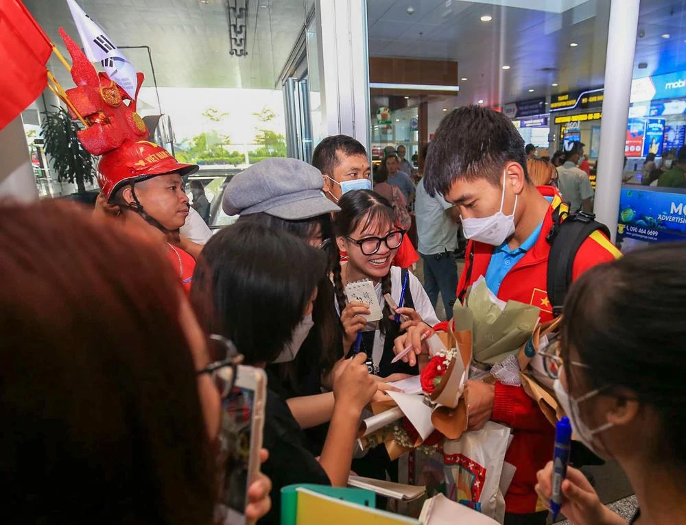 Các cầu thủ U-23 Việt Nam được người hâm mộ vây quanh xin chữ ký. ẢNH: ANH THỎA