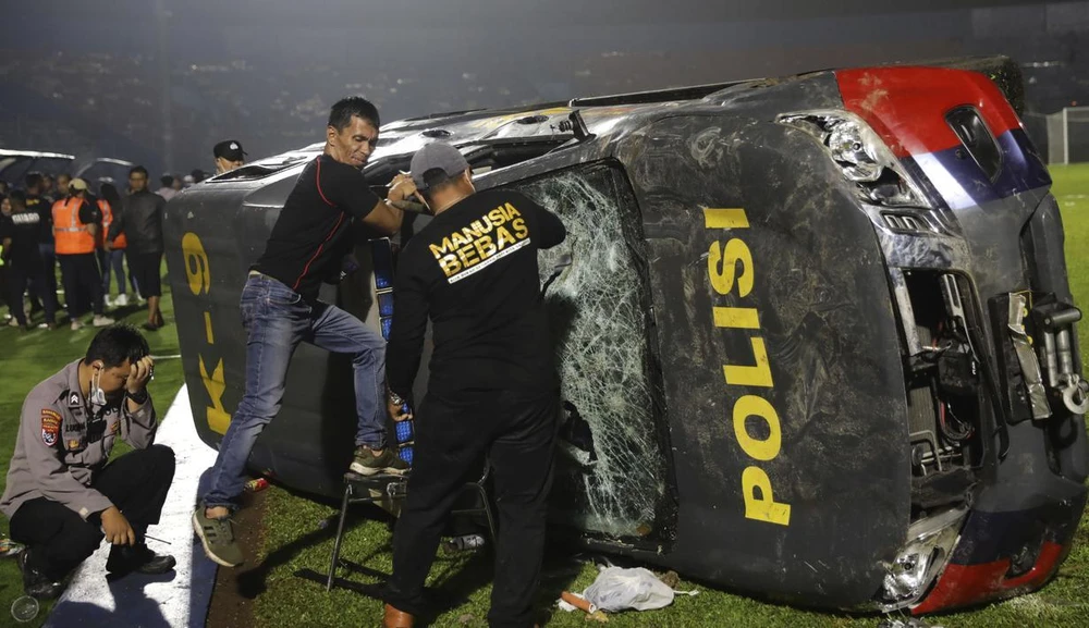 Một số CĐV quá khích đã phá hủy nhiều chiếc xe ô tô của lực lượng chức năng cả bên trong lẫn bên ngoài sân vận động. ẢNH: BOLA Có 13 chiếc xe của lực lượng chức năng bị phá hủy. ẢNH: BOLA Những chiếc xe cháy trơ khung. ẢNH: BOLA Gia đình người nhà các nạn nhân đang chờ đợi và cầu nguyện bên ngoài một bệnh viện ở Malang, Đông Java. ẢNH: BOLA Cảnh sát xác định danh tính thân nhân của các nạn nhân khi họ xếp hàng tìm thi thể người thân của mình. ẢNH: BOLA Tại bệnh viện, một thi thể được đưa lên xe. ẢNH: BOLA Gia đình các nạn nhân đang mong ngóng tin tức ở bên ngoài một bệnh viện tại Malang, Đông Java. ẢNH: BOLA Gia đình các nạn nhân chờ đợi bên ngoài một bệnh viện tại Malang, Đông Java. ẢNH: BOLA