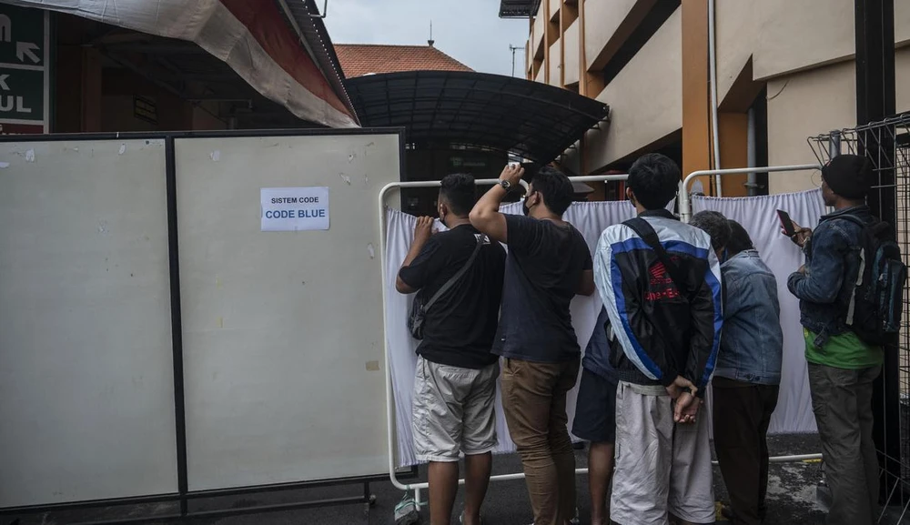 Gia đình các nạn nhân đang mong ngóng tin tức ở bên ngoài một bệnh viện tại Malang, Đông Java. ẢNH: BOLA