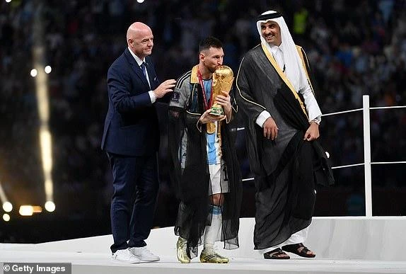 Messi cầm chiếc cúp vô địch tiến về phía đồng đội chuẩn bị màn ăn mừng. ẢNH: GETTY