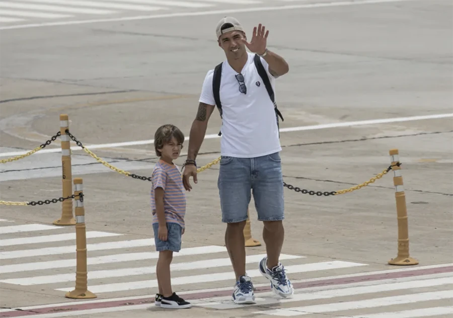 Suarez dắt theo cậu con trai nhỏ vẫy tay chào mọi người. ẢNH: AFP