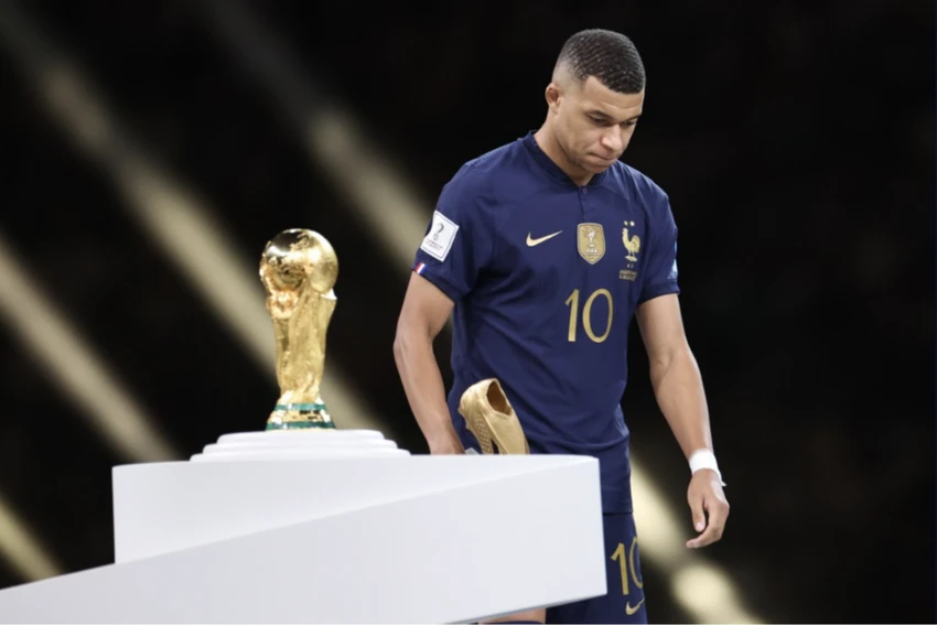 Mbappe cầm chiếc giày vàng cho ngôi vua phá lưới đi qua chiếc cúp vàng World Cup. ẢNH: AP Mbappe cầm chiếc giày vàng cho ngôi vua phá lưới đi qua chiếc cúp vàng World Cup. ẢNH: AP