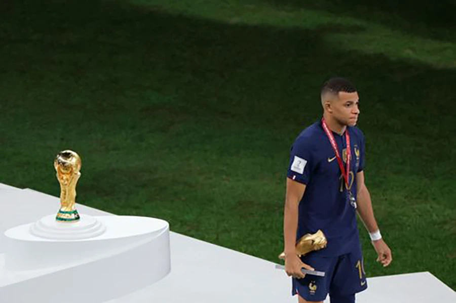 Mbappe cầm danh hiệu vua phá lưới đi lướt qua chiếc cúp World Cup. ẢNH: GETTY