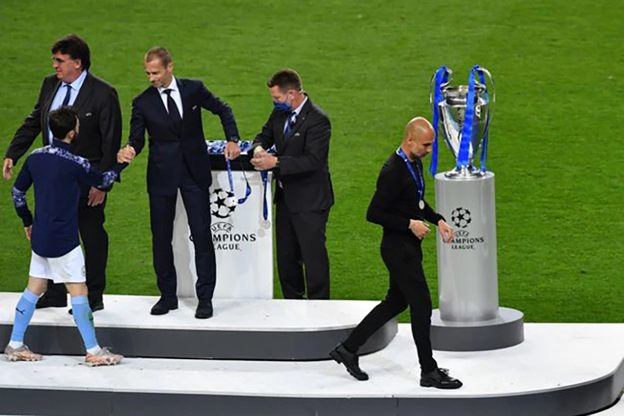 Pep Guardiola lướt qua chiếc cúp vô địch Champions League 2021. ẢNH: GETTY