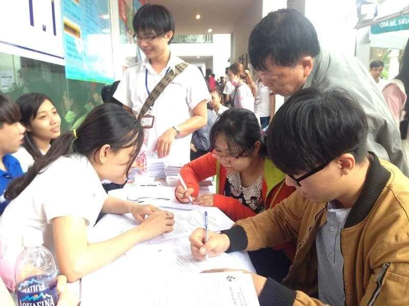 Những người làm công tác tuyển sinh tại các trường đại học hướng dẫn thí sinh điền thông tin đăng ký xét tuyển