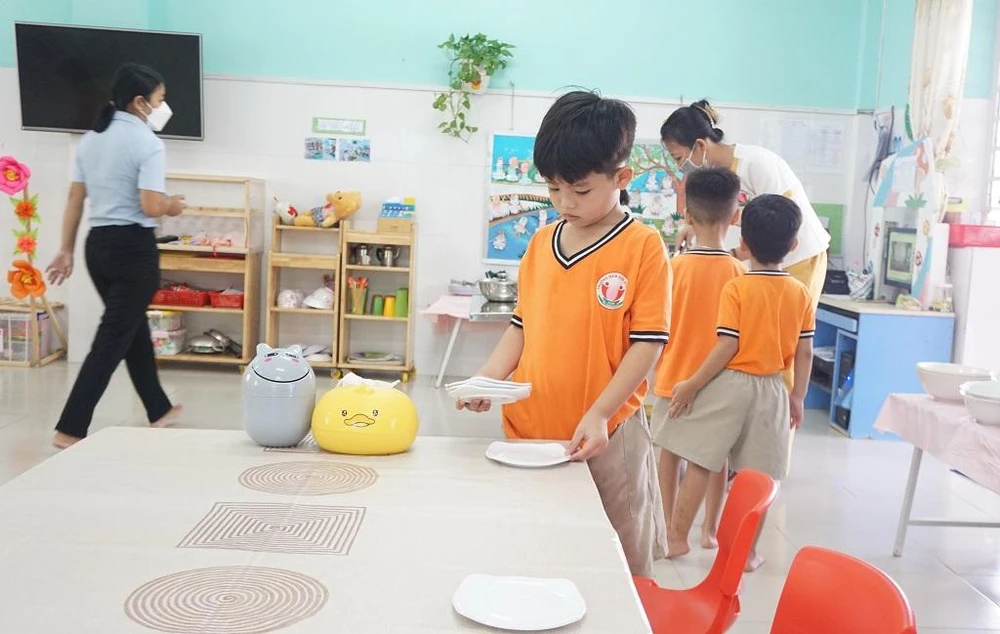 Tại lớp lá 5, tất cả cất vật dụng chuẩn bị cho bữa ăn sạch sẽ, khô ráo. Các bé sẽ cùng giáo viên bày biện bữa ăn. Mỗi bé sẽ có một nhiệm vụ riêng.