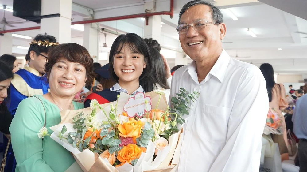 Em Lê Thanh Thảo, học sinh lớp 9 cùng với bố mẹ của mình trong lễ ra trường.