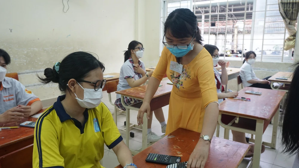 Giám thị kiểm tra vật dụng của thí sinh. Ảnh: NGUYỄN QUYÊN