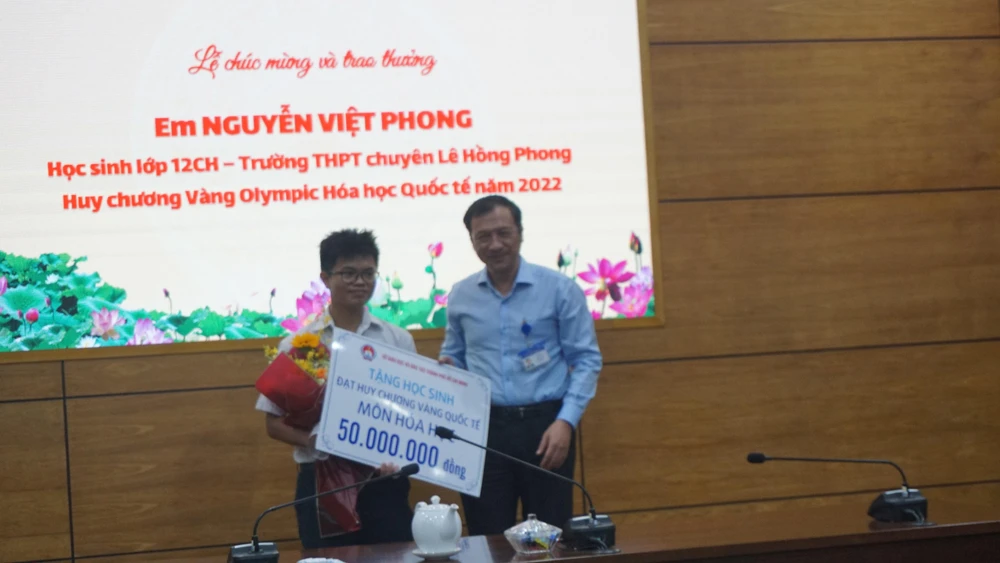 Ông Lê Hoài Nam, Phó giám đốc Sở GD&amp;ĐT đại diện cho Ban thường vụ, Ban giám đốc Sở trao tặng phần quà cho em Nguyễn Việt Phong. Ảnh: NQ