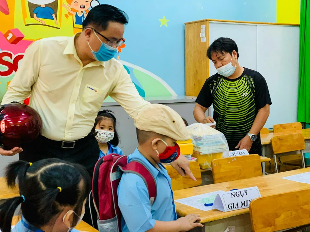 Anh Nguỵ Văn Tèo dẫn con vào tận lớp. Ảnh: TP