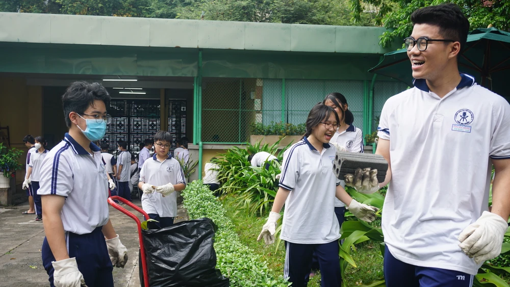 Nụ cười rạng rỡ trên môi khi các em tham gia dọn vệ sinh khuôn viên trường. Ảnh: NGUYỄN QUYÊN