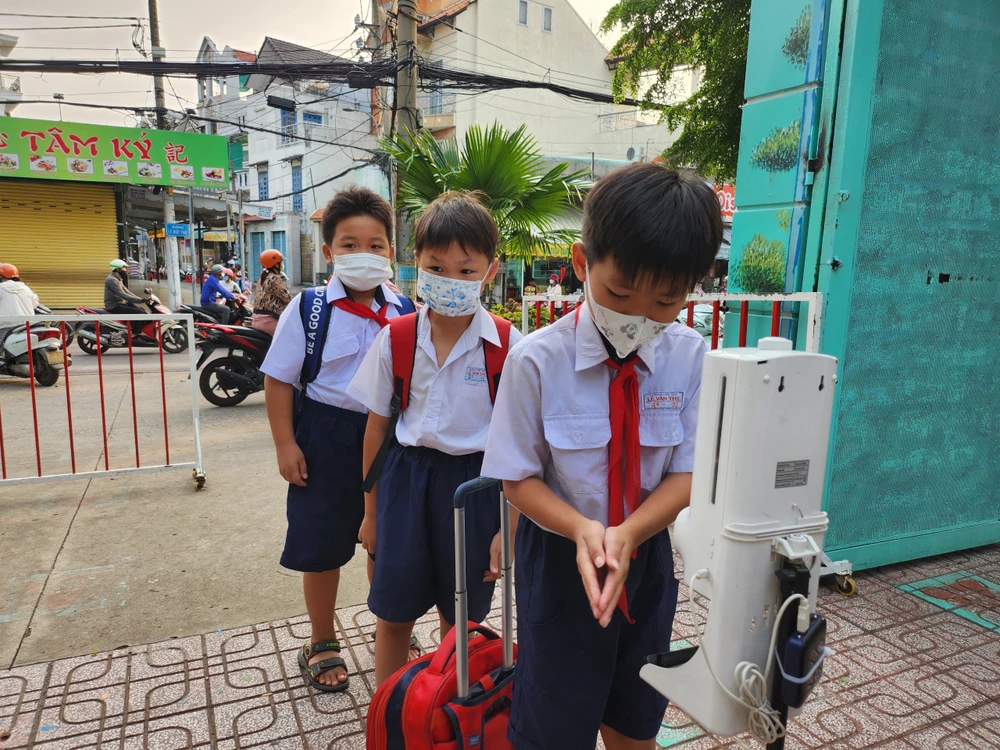 Học sinh Trường Tiểu học Lê Văn Thọ tuân thủ nghiêm việc đeo khẩu trang và rửa tay sát khuẩn trước khi vào trường.
