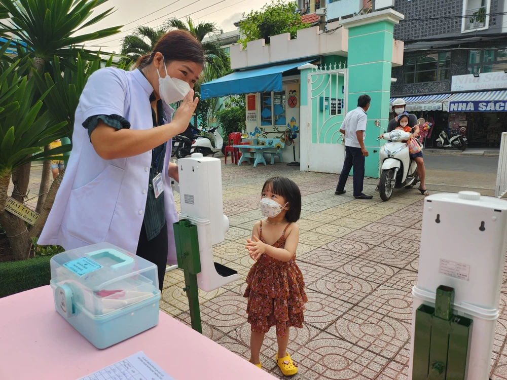 Nhân viên y tế của trường hướng dẫn các bé cách rửa tay đúng cách.