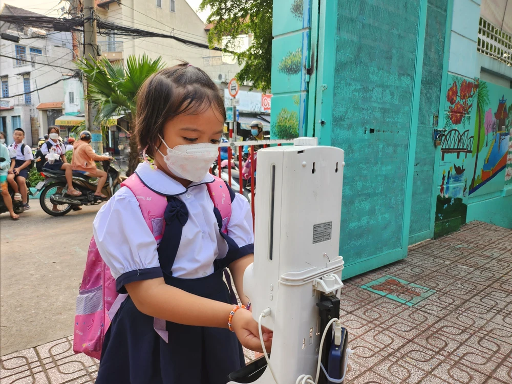 Sau khi được hướng dẫn, bé lớp 1 rửa tay trước khi vào trường.