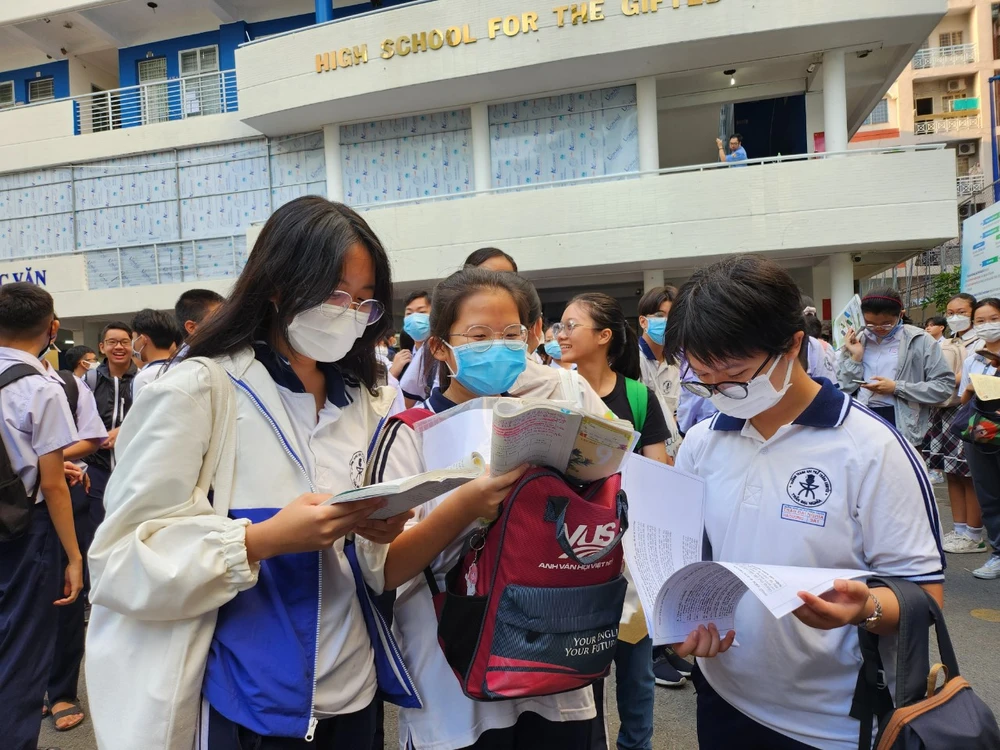 Thí sinh tranh thủ ôn bài trước khi vào phòng thi. Ảnh: NGUYỄN QUYÊN