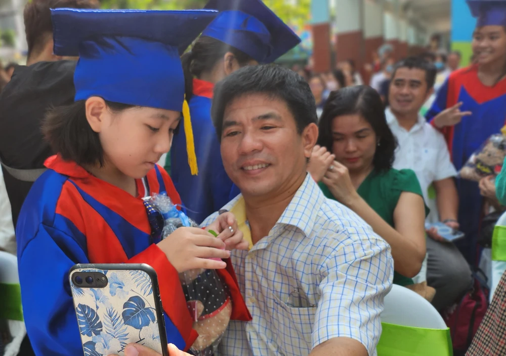 Sau những phút giây sôi động, sân trường lặng im trong khoảnh khắc học sinh từng bước tiến lại gần bố mẹ để cài lên bông hoa tươi thắm với tất cả lòng biết ơn và sự kính yêu.