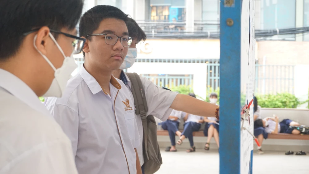 Thí sinh xem danh sách phòng thi tại điểm thi THCS Nguyễn Gia Thiều. Ảnh: NGUYỄN QUYÊN