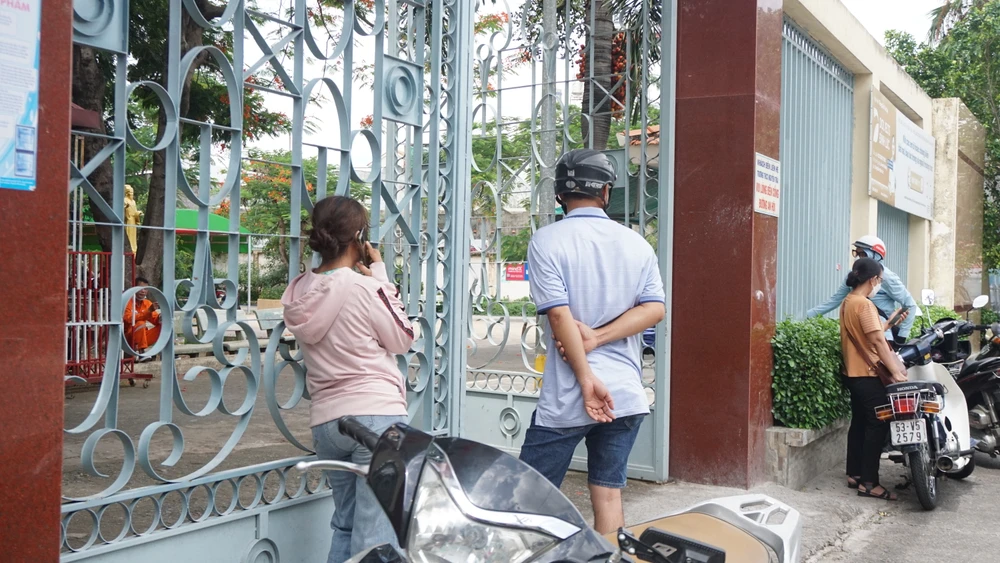 Vợ chồng chị NH tức tốc chạy đến điểm thi khi nghe tin con chưa vào phòng. Ảnh: NGUYỄN QUYÊN