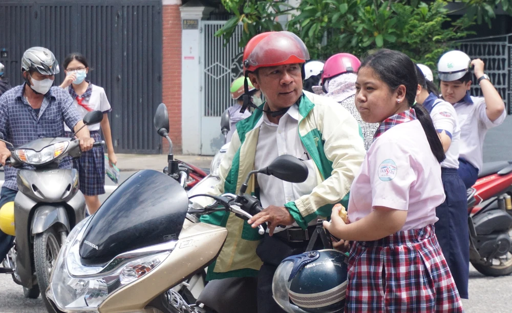 Sợ con đi trễ, từ 12 giờ 30 nhiều phụ huynh đội nắng chở con đến điểm thi. Ảnh: NGUYỄN QUYÊN