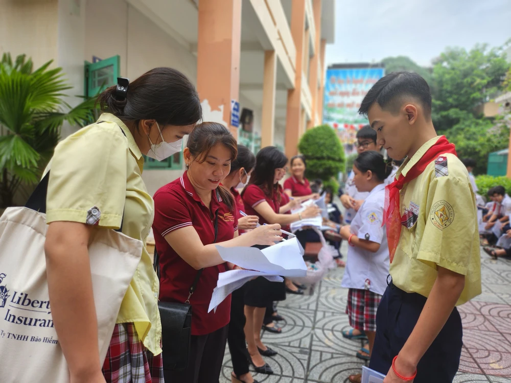 Giáo viên Trường THCS Phan Tây Hồ điểm danh thí sinh trước giờ thi. Ảnh: NGUYỄN QUYÊN