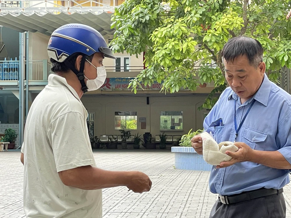 Và vội vã mang đồ khi con quên. Ảnh: TRẦN MINH